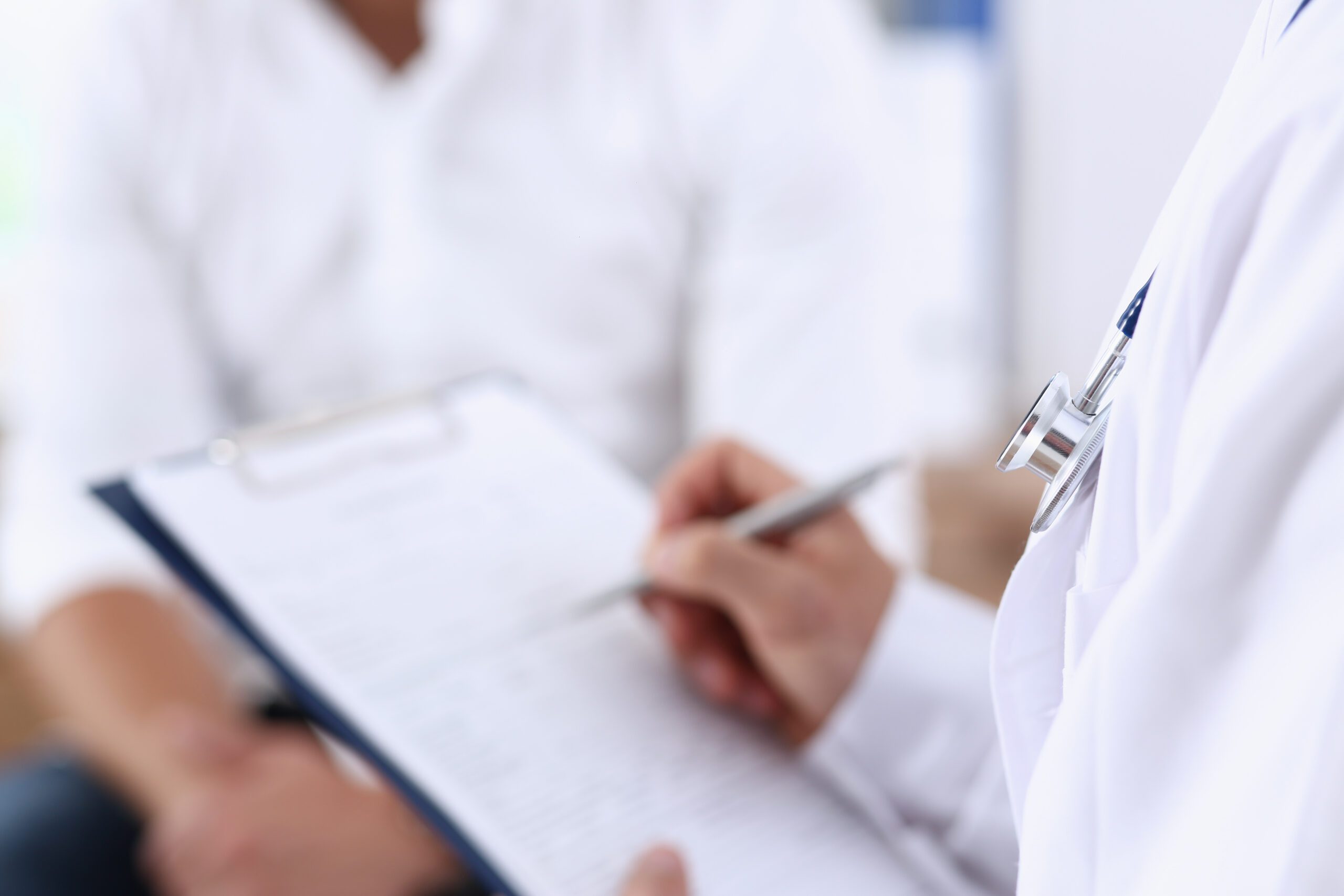 Male doctor hand hold silver pen and showing pad. Physical agreement form signature disease prevention ward round reception consent contract sign prescribe remedy healthy lifestyle concept