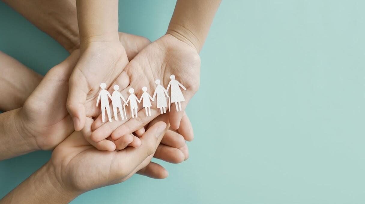 Family hands all holding a paper cutout.