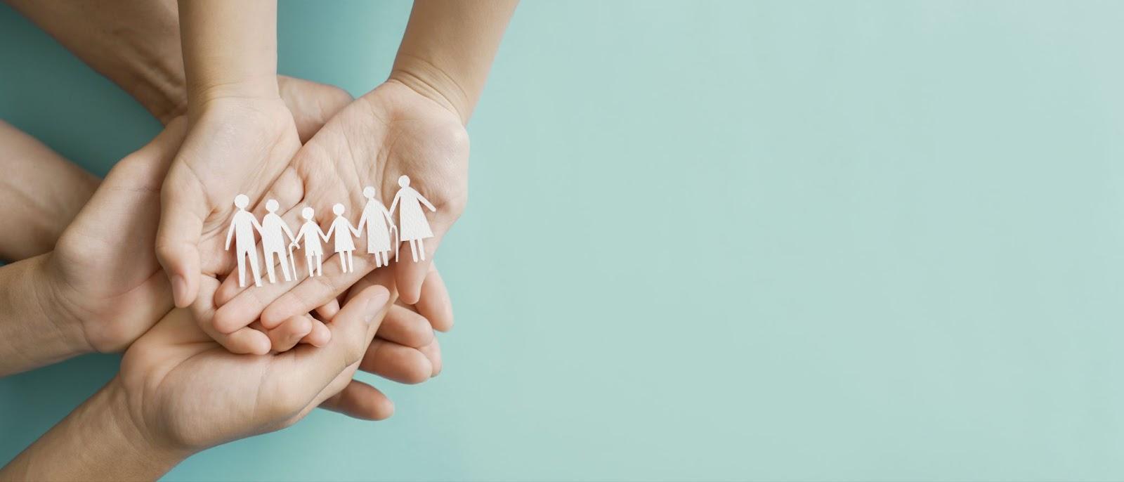 Family hands all holding a paper cutout.